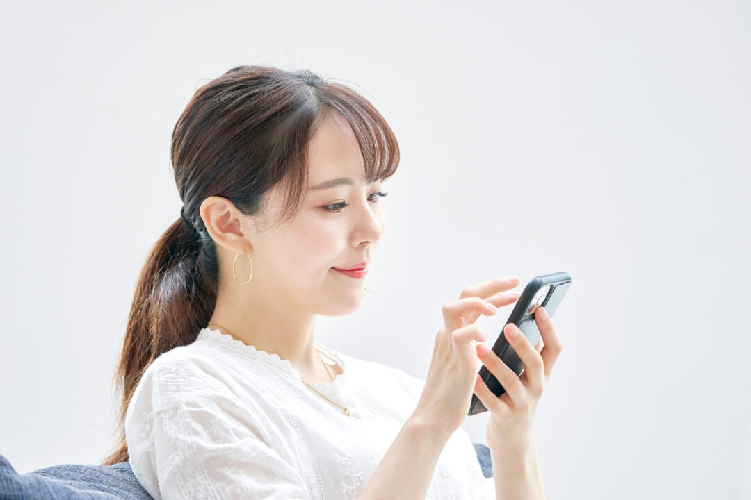 Asian,Woman,Using,The,Smart,Phone,On,The,Sofa